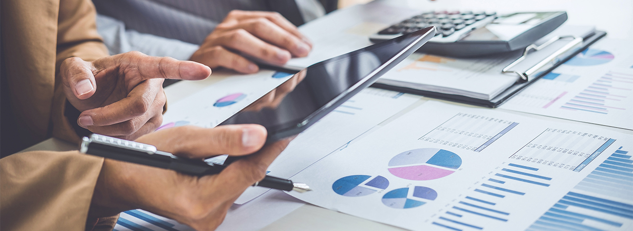 Hands of a professional using a calculator at an office desk for accounting tasks