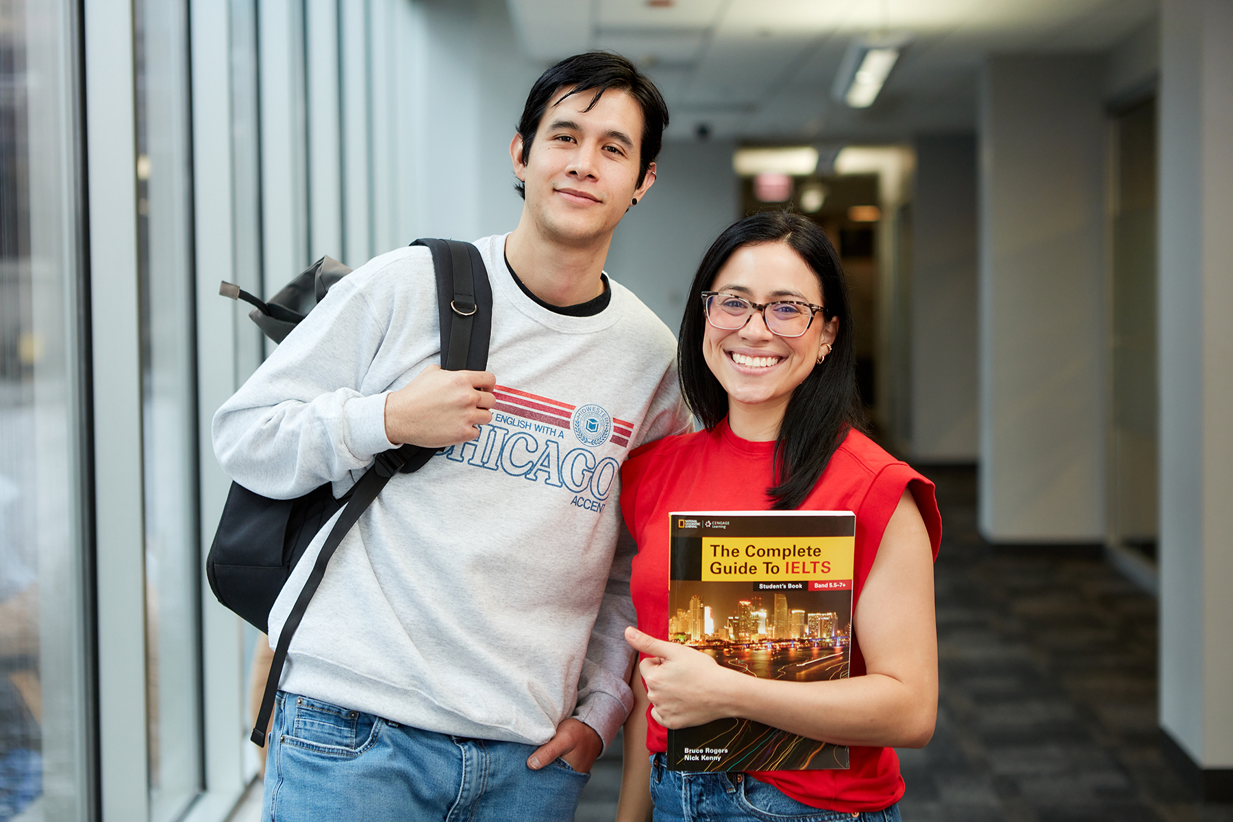 Two smiling students in the MCC hallway.