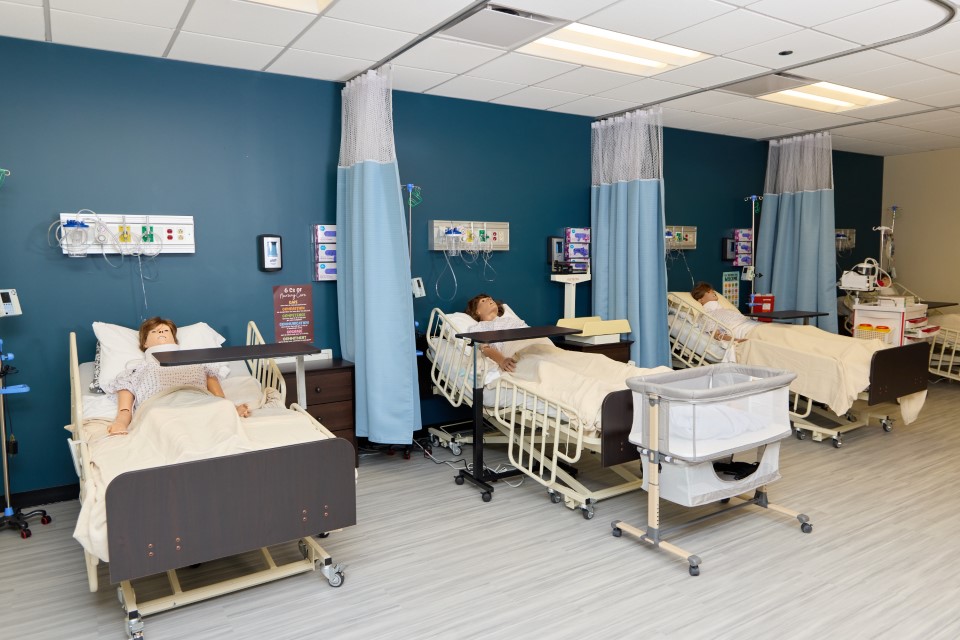 Midwestern Career College Simulation Lab showing hospital beds and three high-fidelity MedVision patient manikins used for Licensed Practical Nursing clinical training