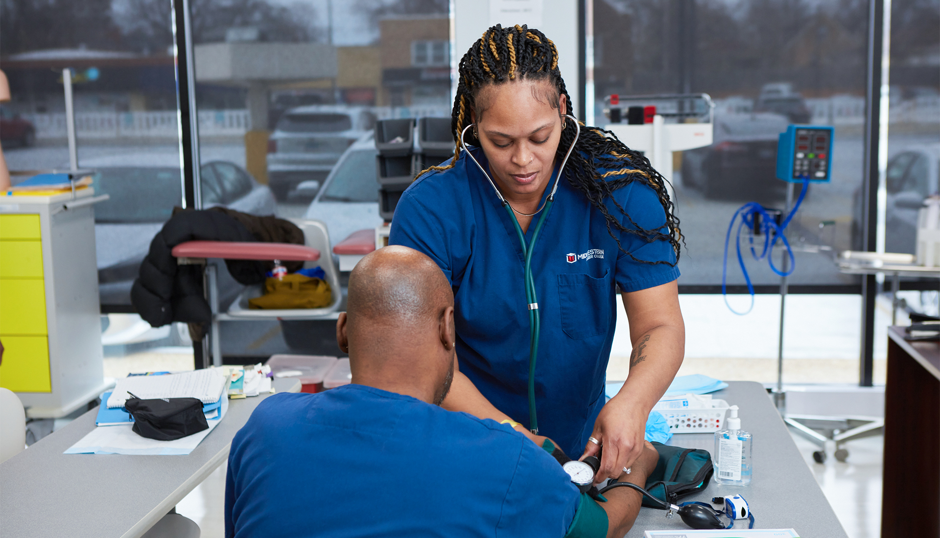 Medical assisting students practicing blood pressure skills in a clinical lab at Midwestern Career College