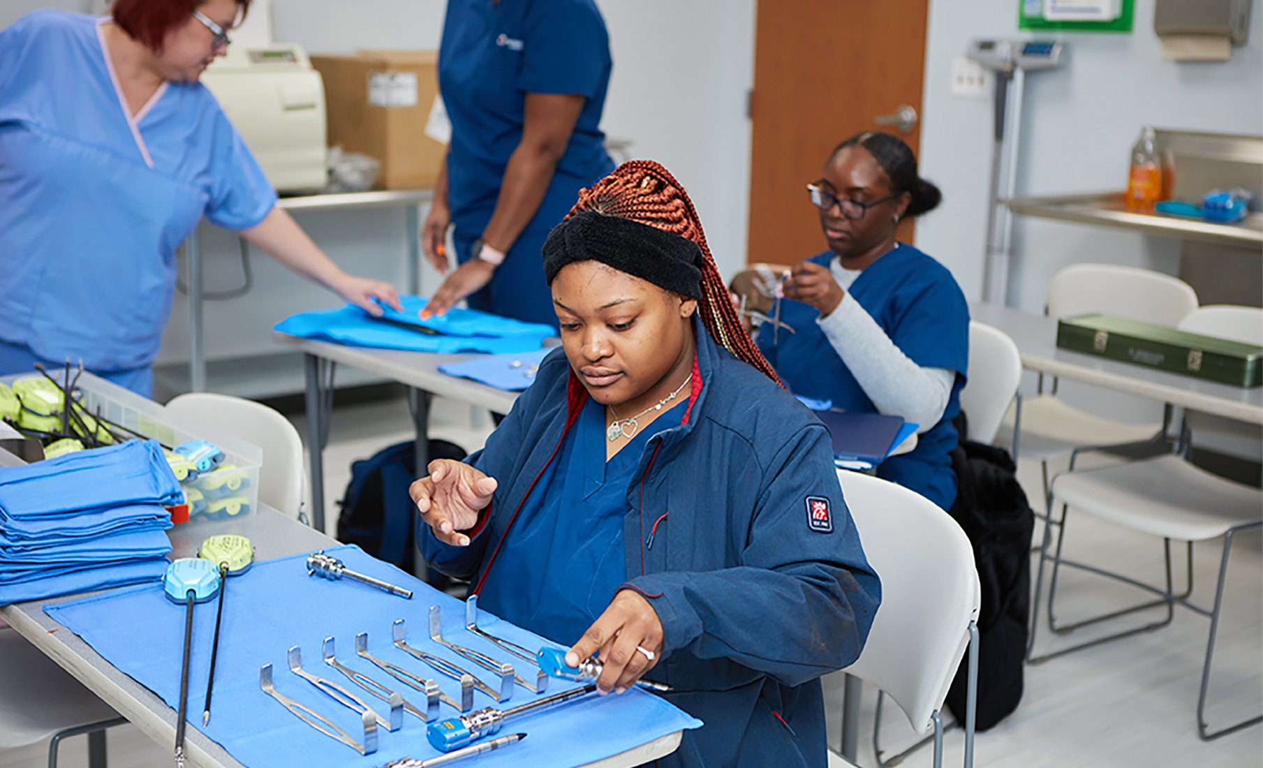 Sterile processing technician students practicing instrument handling in a training lab at MCC